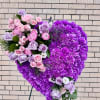 Heart-shaped purple floral standing arrangement with pink and lavender roses