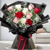 Bouquet of red, pink, and white roses wrapped in black paper