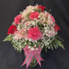 Pink and red flower arrangement in a glass vase with a pink ribbon