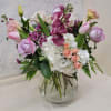 A variety of garden flowers in pastel colors arranged in a large