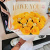 Yellow rose bouquet with gold-wrapped chocolates in white and peach wrapping