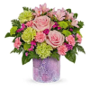 Pink roses and mixed blooms arranged in a purple vase