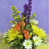 Basket arrangement with yellow, white, orange, and purple flowers