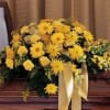 Yellow floral casket spray with a cream ribbon
