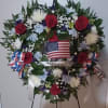 Heart-shaped floral wreath with red roses and an American flag