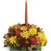 Autumn floral centerpiece with a tall orange taper candle