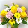 Yellow roses and pink, white, and yellow daisies in a vase