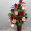 Red and pink roses arranged in a tall vase