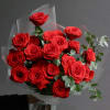 Bouquet of red roses wrapped in translucent paper