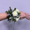 White rose wrist corsage with silver ribbon and greenery