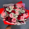 Bouquet of pink and red roses wrapped in red and white paper
