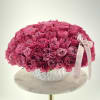 Large dome of pink roses in a white vase with a ribbon bow