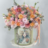 Mixed pink and peach bouquet in a decorated green box with ribbon
