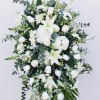 Large white floral standing spray with lilies, roses, and daisies