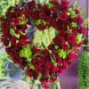 Heart-shaped floral wreath of red roses with green accents on an easel