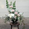 Romantic garden-style arrangement in a keepsake container. Abundant roses and lush overflowing