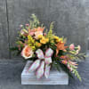 Mixed bouquet of peach roses, yellow spray roses, and orange lilies in a wooden box