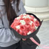 Bouquet of pink roses with small white flowers wrapped in black paper