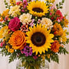 A cheerful mix of golden sunflowers, vibrant roses, colorful seasonal blooms, and