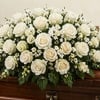 A beautiful sympathy arrangement featuring fresh white roses, baby&rsquo;s breath, and seasonal