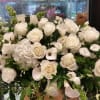 Large white rose arrangement with calla lilies and greenery