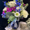 Bouquet of white roses, blue flowers, and pink dianthus in a blue vase