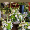 Sympathy floral arrangements with white roses and green blooms in vases and baskets