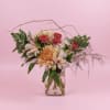 Mixed pink and peach flowers in a clear glass vase