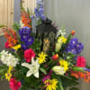 Colorful floral arrangement with lilies, daisies, and snapdragons around a black lantern