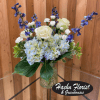 White roses and blue hydrangeas in a glass vase