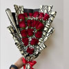 Bouquet of red roses wrapped in patterned paper with a red ribbon