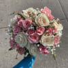 Handheld bouquet of pink and white roses with baby's breath