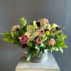 Mixed bouquet in a ribbed metal vase with burgundy and pale pink blooms