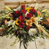 Large bouquet of red roses, white lilies, and sunflowers with a gold ribbon