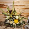 Tall mixed floral arrangement with white lilies, yellow gerbera daisies, and greenery