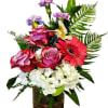 A bright gerbera centers a three roses and hydrangeas in this compact