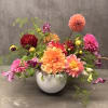Colorful dahlia arrangement in a white vase