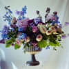 Large bouquet of pink, purple, and blue flowers in a pedestal vase