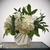 White hydrangea and rose arrangement in a clear glass vase