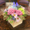 Pink roses and pastel mixed flowers arranged in a wooden box