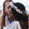 Bride wearing a floral crown embraces a man at an outdoor wedding