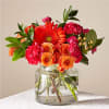 Orange and pink mixed bouquet in a clear glass vase