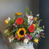 Mixed bouquet with sunflowers, gerbera daisies, and roses in a vase