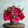 Mixed bouquet of white, pink, orange, and magenta flowers in a green vase