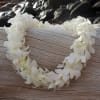 White flower lei on a wooden surface