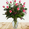 One dozen pink roses with accent flowers.