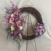 Floral wreath with pink and purple flowers on a twig ring stand
