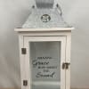 White lantern with glass door and "Amazing Grace" text