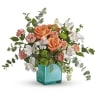 Peach roses and white flowers in a turquoise vase