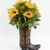 Sunny sunflowers burst from a decorative brown cowboy boot vase, creating a